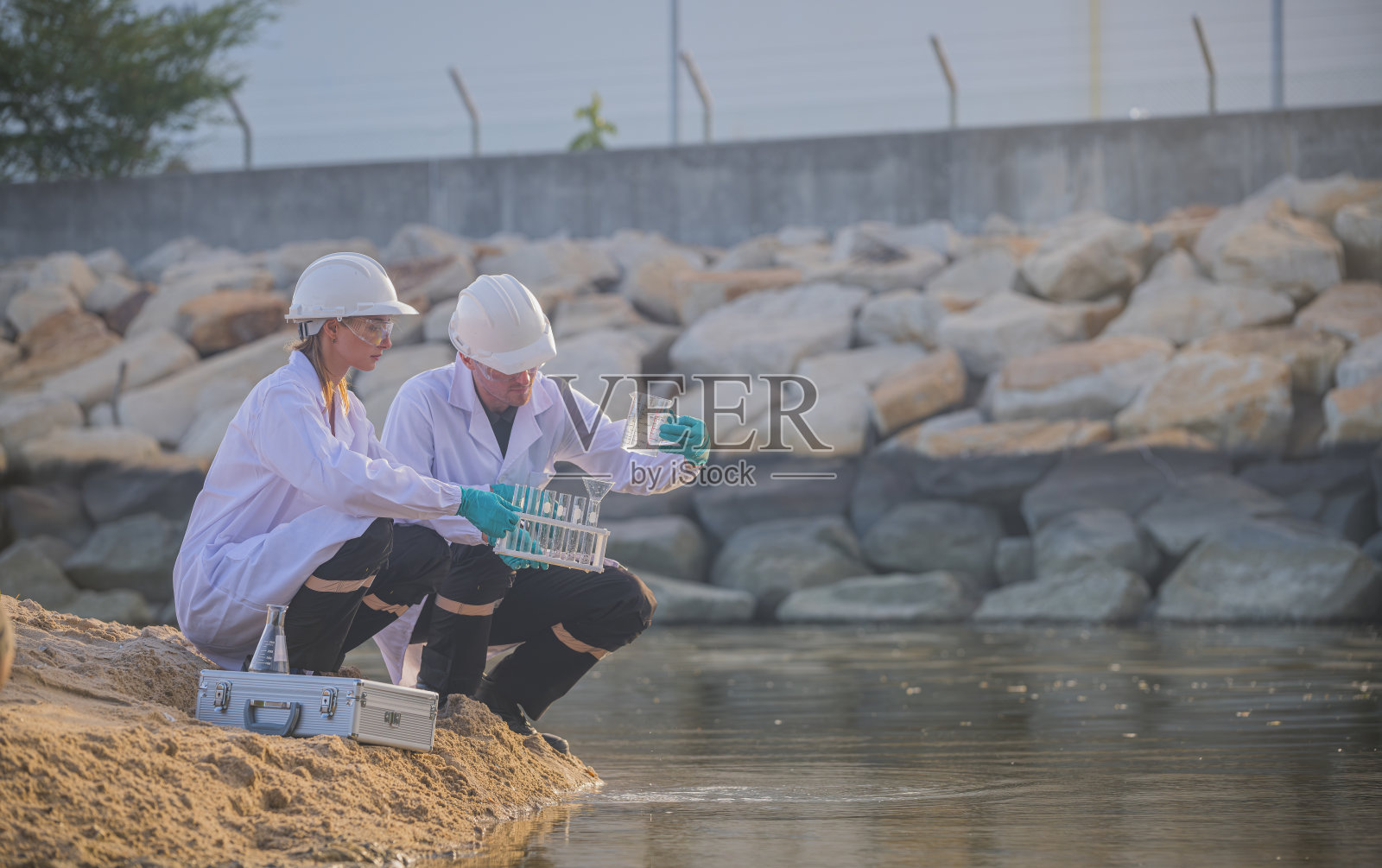 科学家在实验室中穿着防护服和手套，进行水质分析和废水检测，以研究环境污染问题。照片摄影图片
