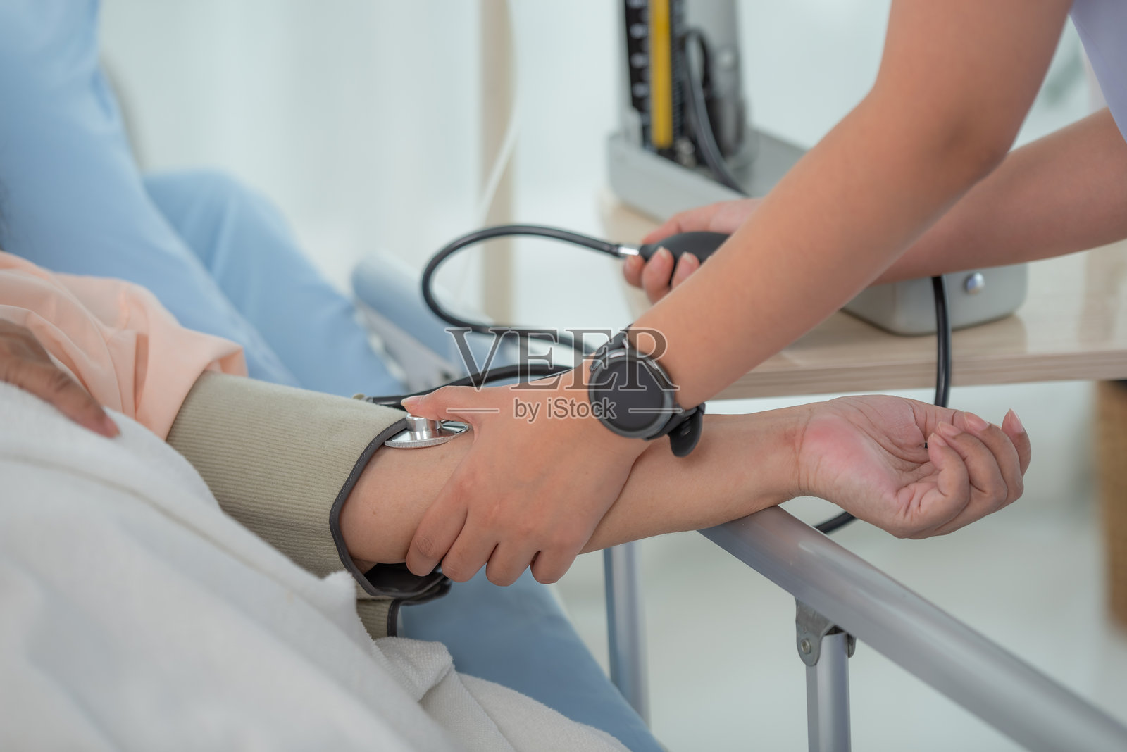 医生的手在为老年女性患者测量血压的特写镜头照片摄影图片