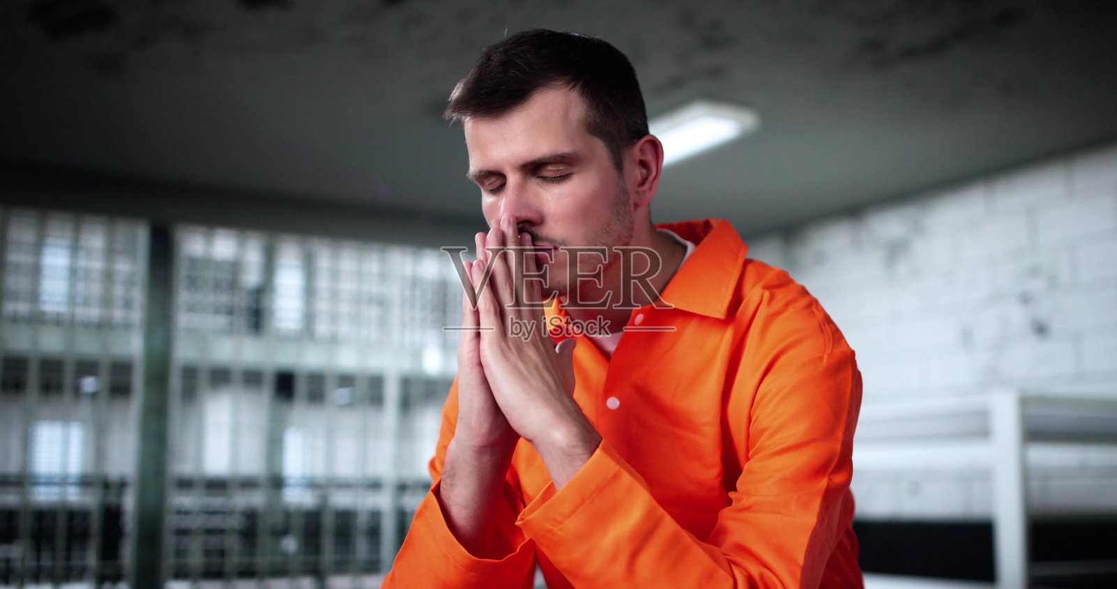 男子在监狱中向上帝祈祷寻求怜悯照片摄影图片