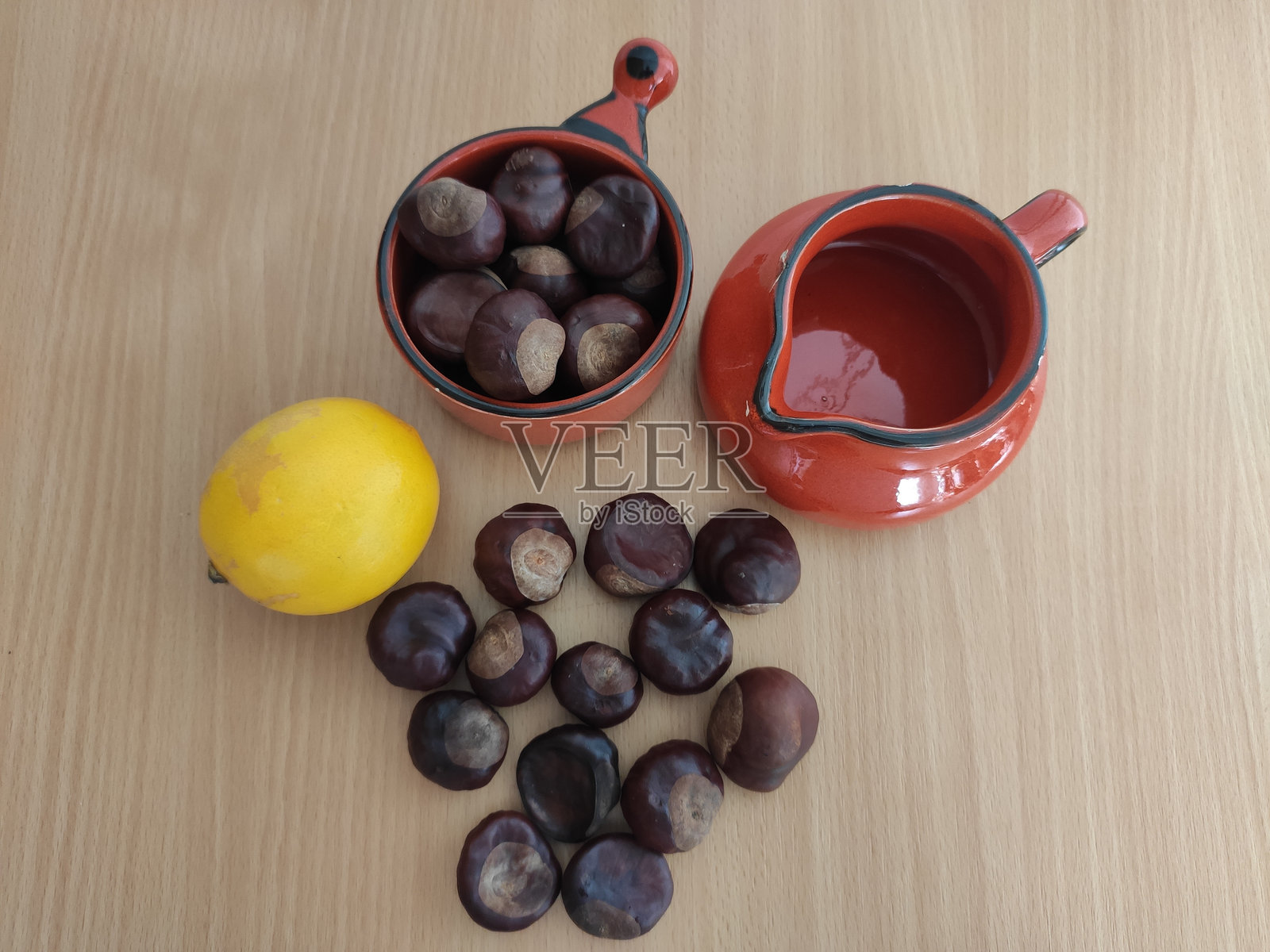 桌子上的黄色柠檬和闪亮的棕色栗子照片摄影图片