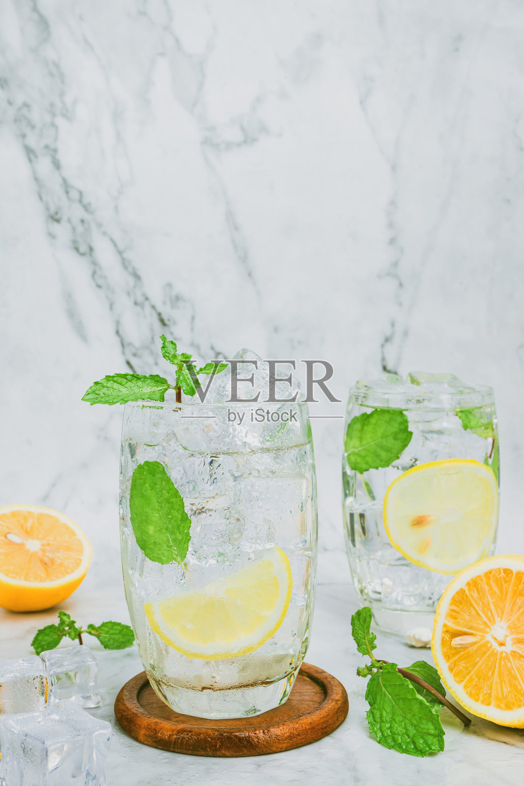 清澈玻璃杯中的清爽柠檬水，鲜艳的黄色来自新鲜的柑橘水果，捕捉到的工作室拍摄，带来清凉而充满活力的夏日饮品体验。照片摄影图片