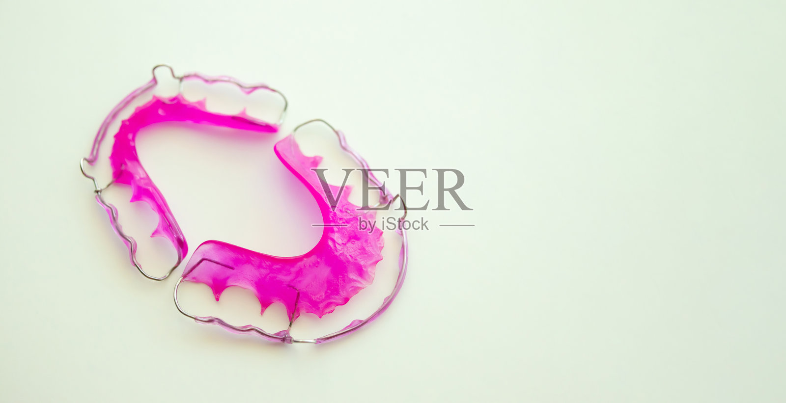 粉色丙烯酸牙齿保持器在白色背景上照片摄影图片