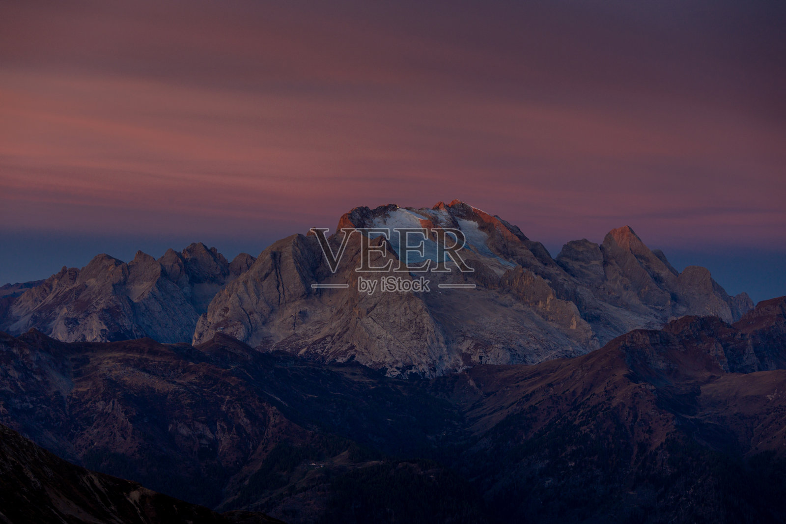 山中的日落。红色和橙色的燃烧天空在阿尔卑斯山脉的地平线后面。照片摄影图片