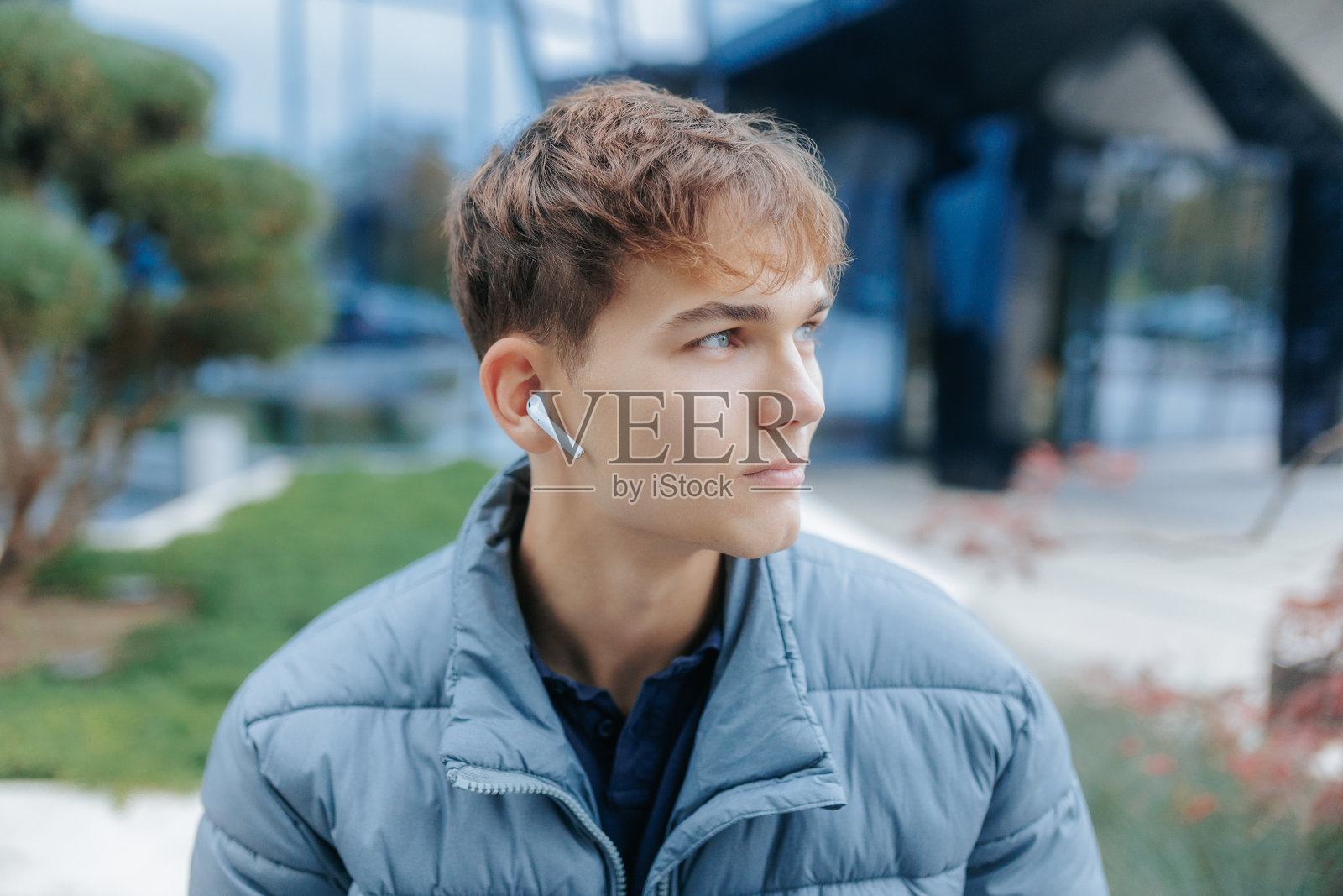 年轻男子在休闲的城市环境中佩戴无线耳机照片摄影图片