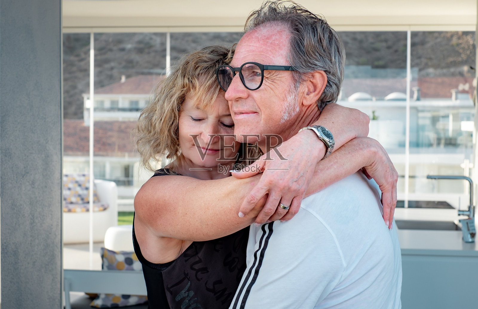 帅气的中年夫妇微笑着相拥，享受亲密的时刻，浪漫的男女紧紧相拥，感受彼此的温暖。照片摄影图片