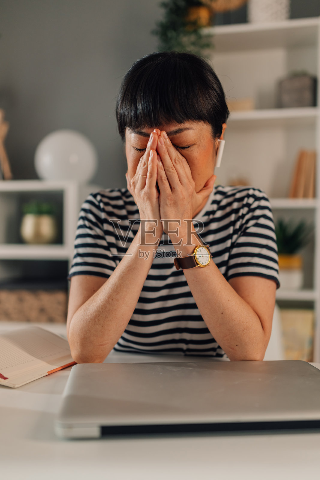 亚洲女性在办公室专注思考，使用笔记本电脑。照片摄影图片
