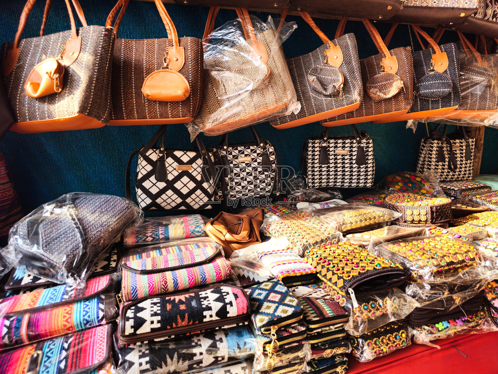 一系列精美设计的包和钱包，包括编织和刺绣图案，陈列在商店里。照片摄影图片