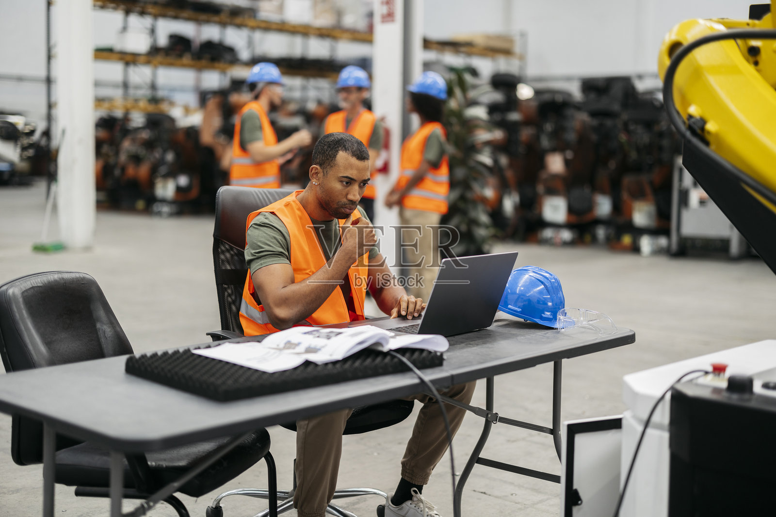 工程师在现代工厂中编程机器人手臂照片摄影图片