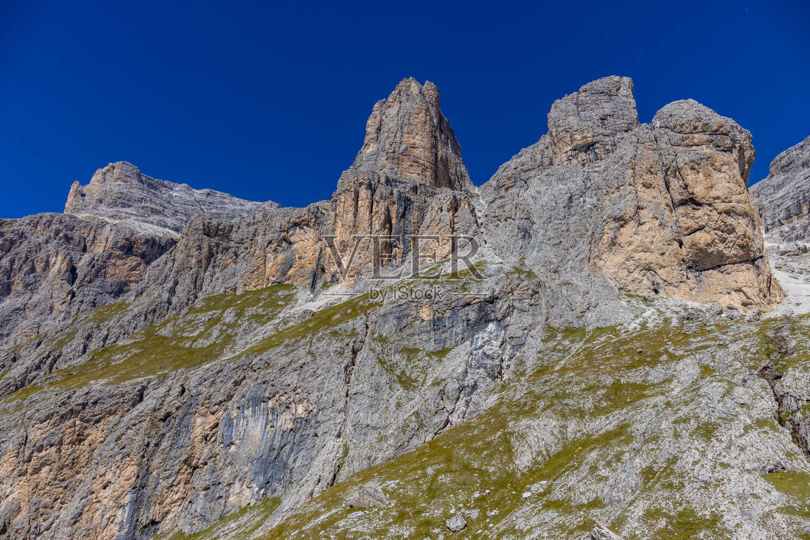 阳光明媚的多洛米蒂山脉。夏季蓝天和几朵云下的多洛米蒂阿尔卑斯山岩石山峰。照片摄影图片