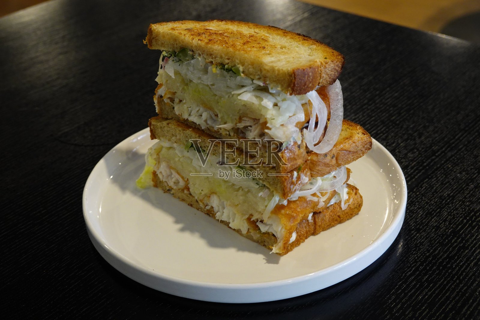 美味的三明治，夹满了新鲜的食材，如脆嫩的蔬菜、鲜嫩的肉类和美味的酱料，夹在两片柔软的面包之间。非常适合快速而令人满意的餐点。照片摄影图片