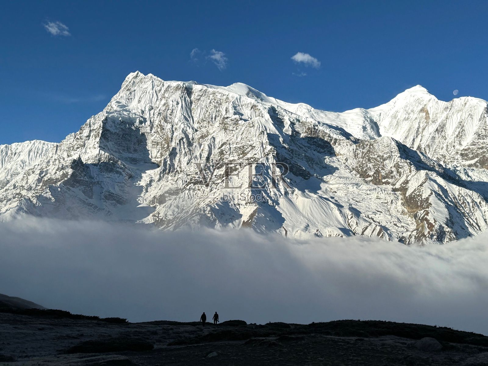 登山者在通往雪山顶峰的山路上照片摄影图片