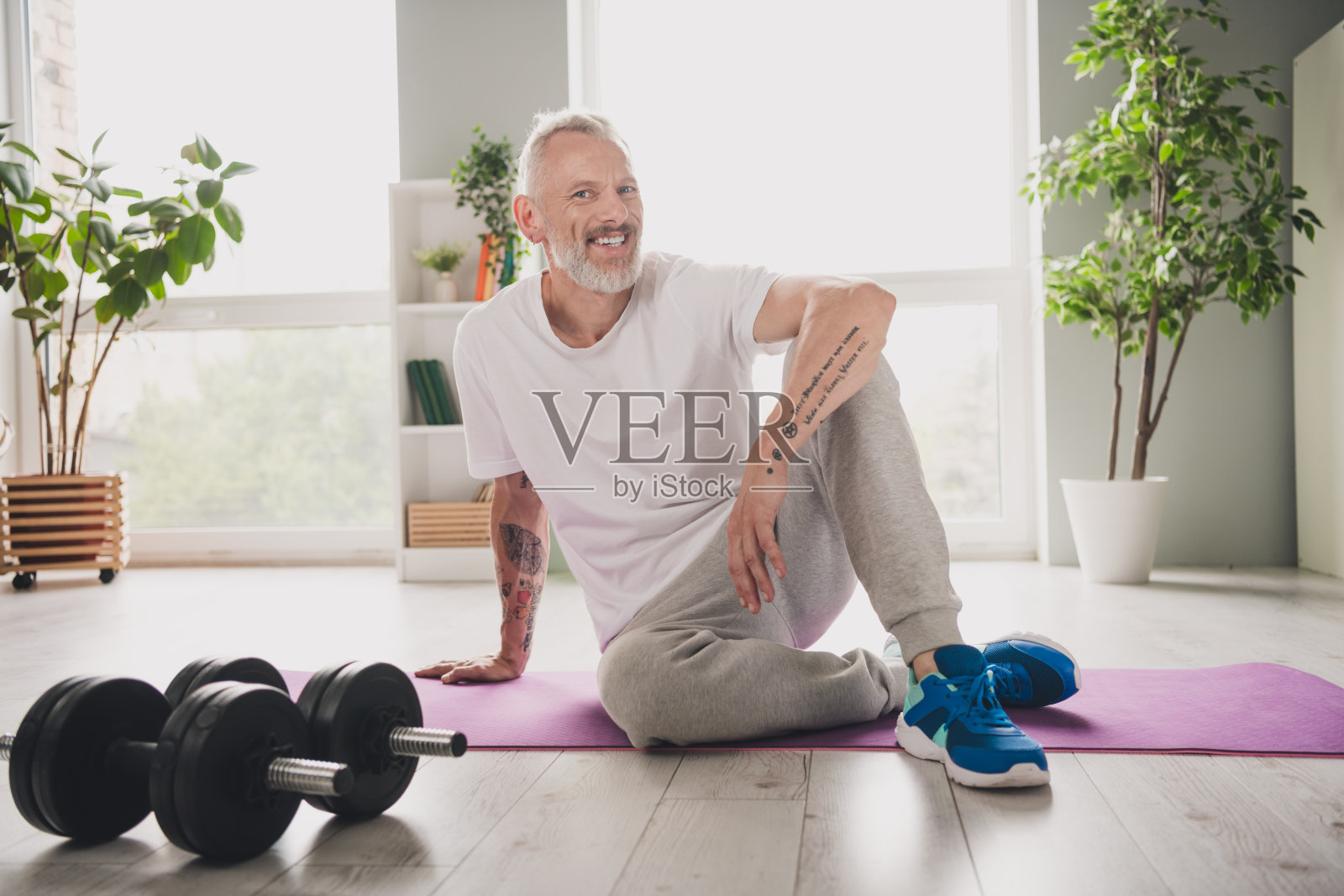 老年男性享受健康生活方式，进行室内锻炼和瑜伽课程照片摄影图片