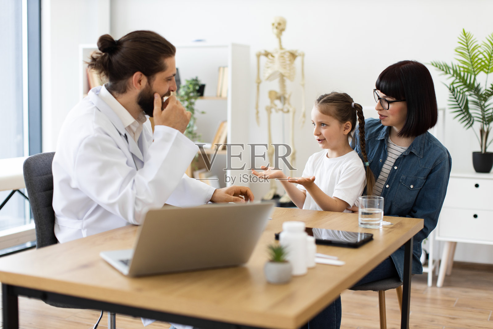 白人医生在诊所与年轻女孩和女性讨论健康问题照片摄影图片