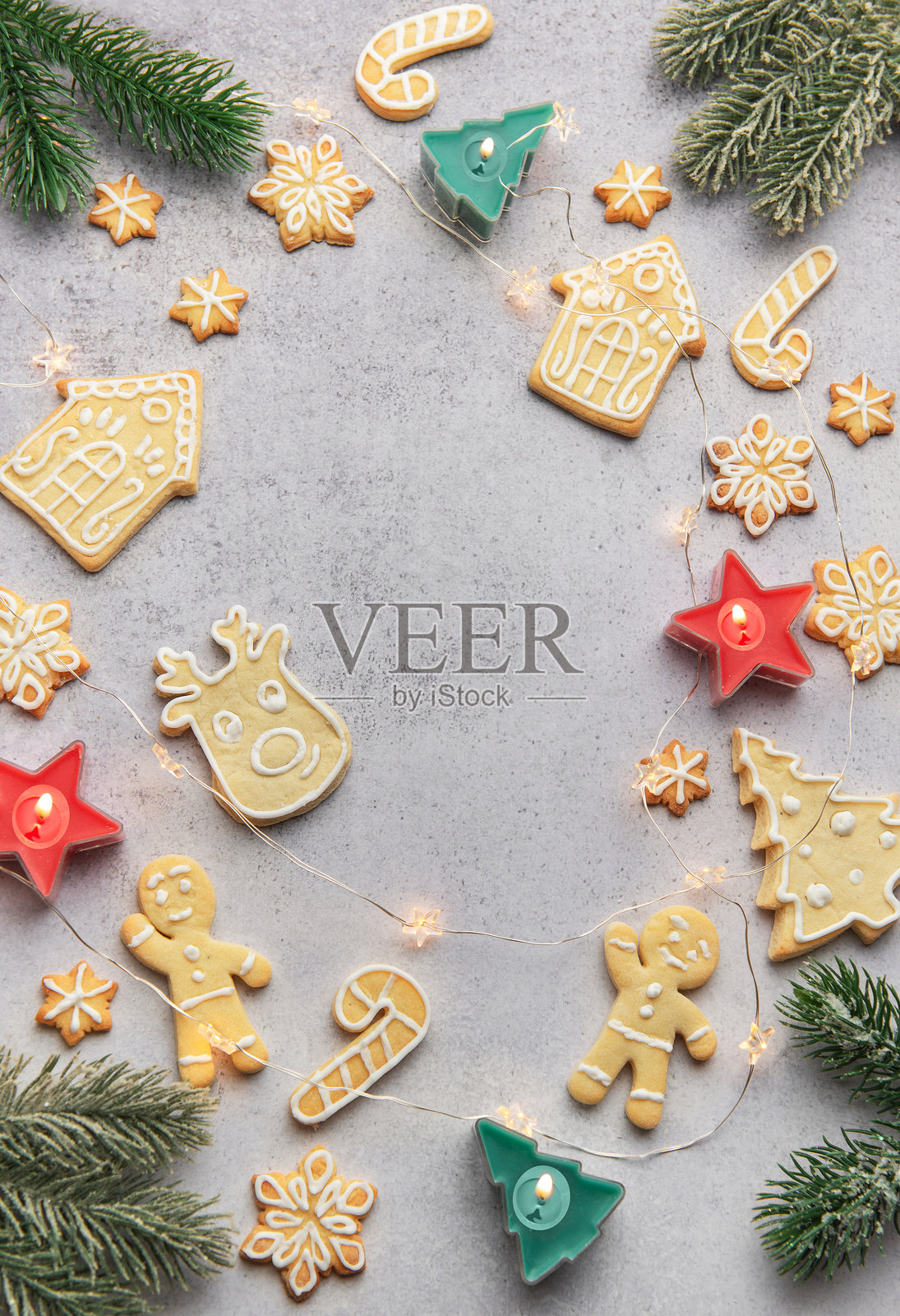 圣诞姜饼饼干环绕着点亮的蜡烛，营造出节日的氛围照片摄影图片