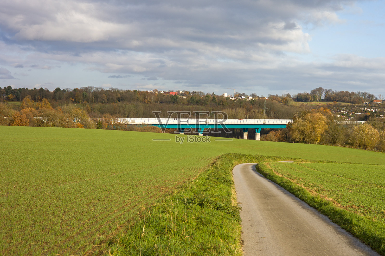 阳光明媚的多云日子里，远眺田野、森林和背景中的海灵豪斯，以及安根塔尔A44高速公路桥。照片摄影图片