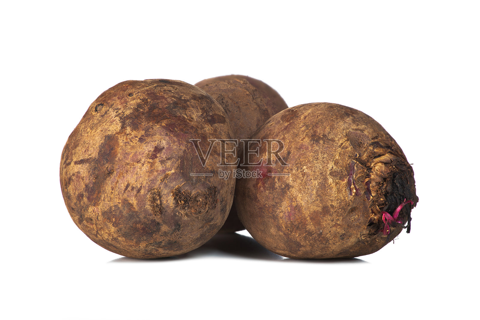 三颗甜菜静静地放在白色表面上照片摄影图片