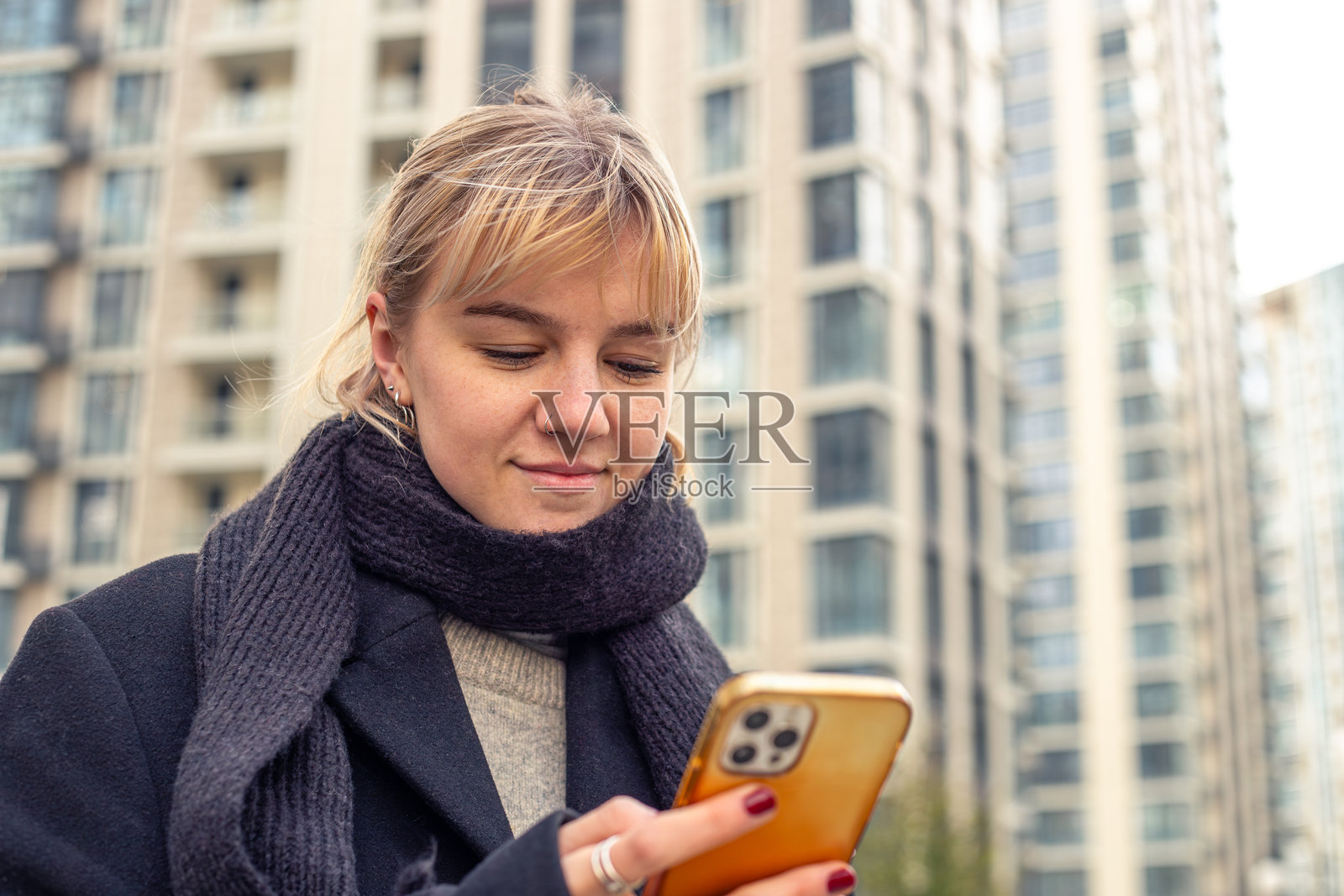 年轻漂亮的女性在城市街道上。女性在城市中使用手机。照片摄影图片