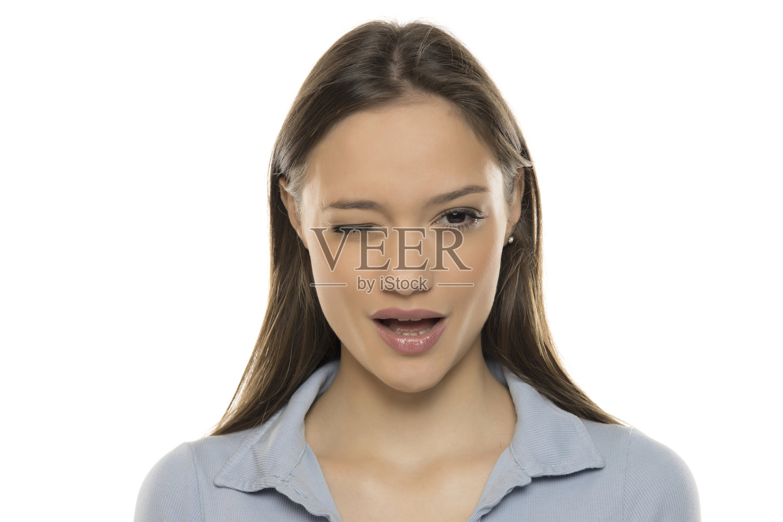 一位美丽的年轻女性在白色摄影棚背景下眨眼，化着妆。照片摄影图片