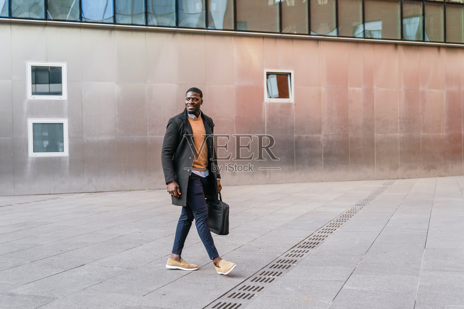 商人在办公大楼外走路，手提公文包照片摄影图片