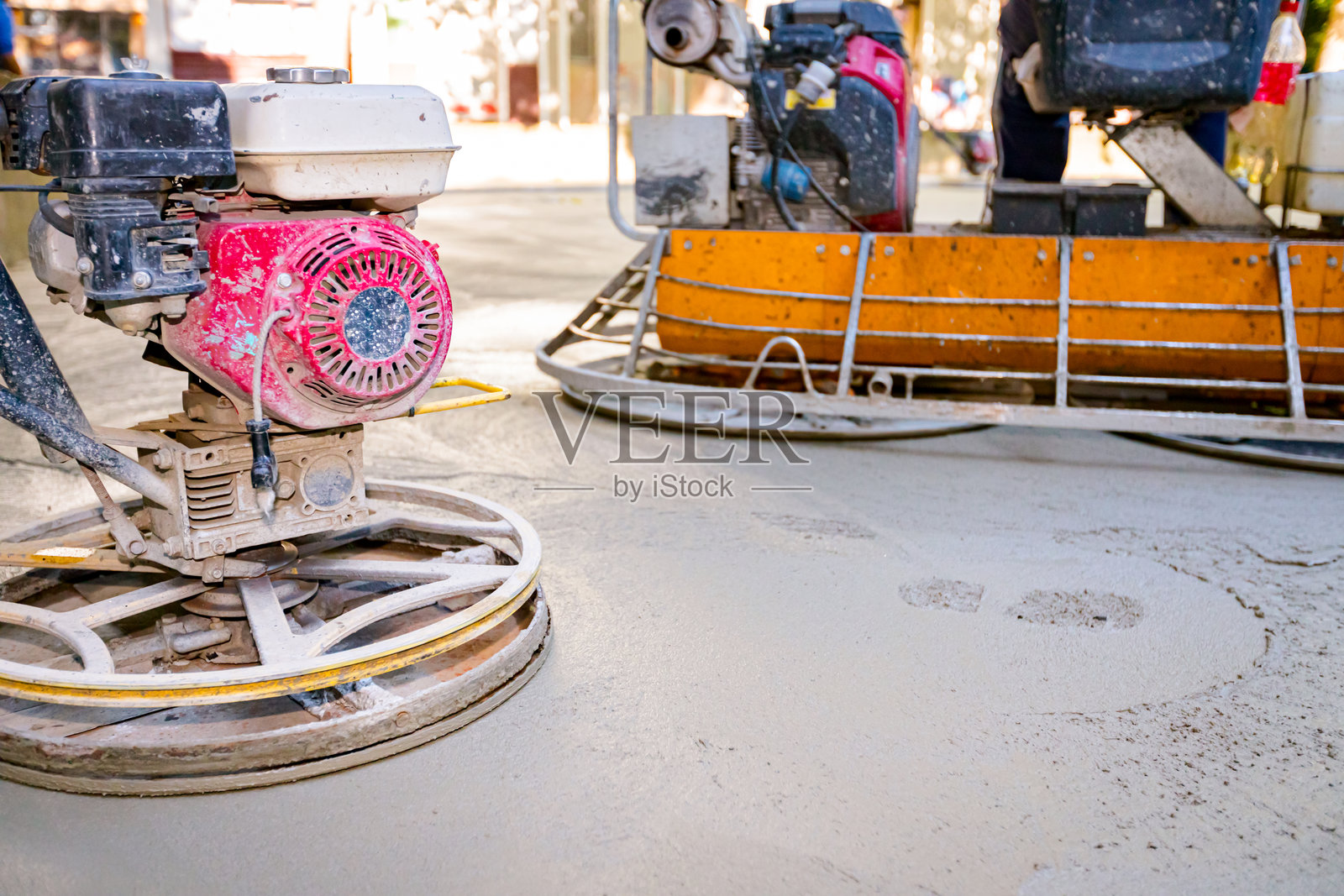 两种带发动机的抹光机，用于平整和修整混凝土表面照片摄影图片