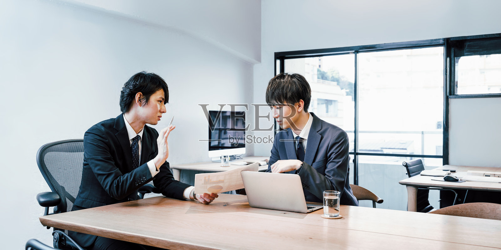 两位二三十岁的年轻员工在办公室相遇照片摄影图片