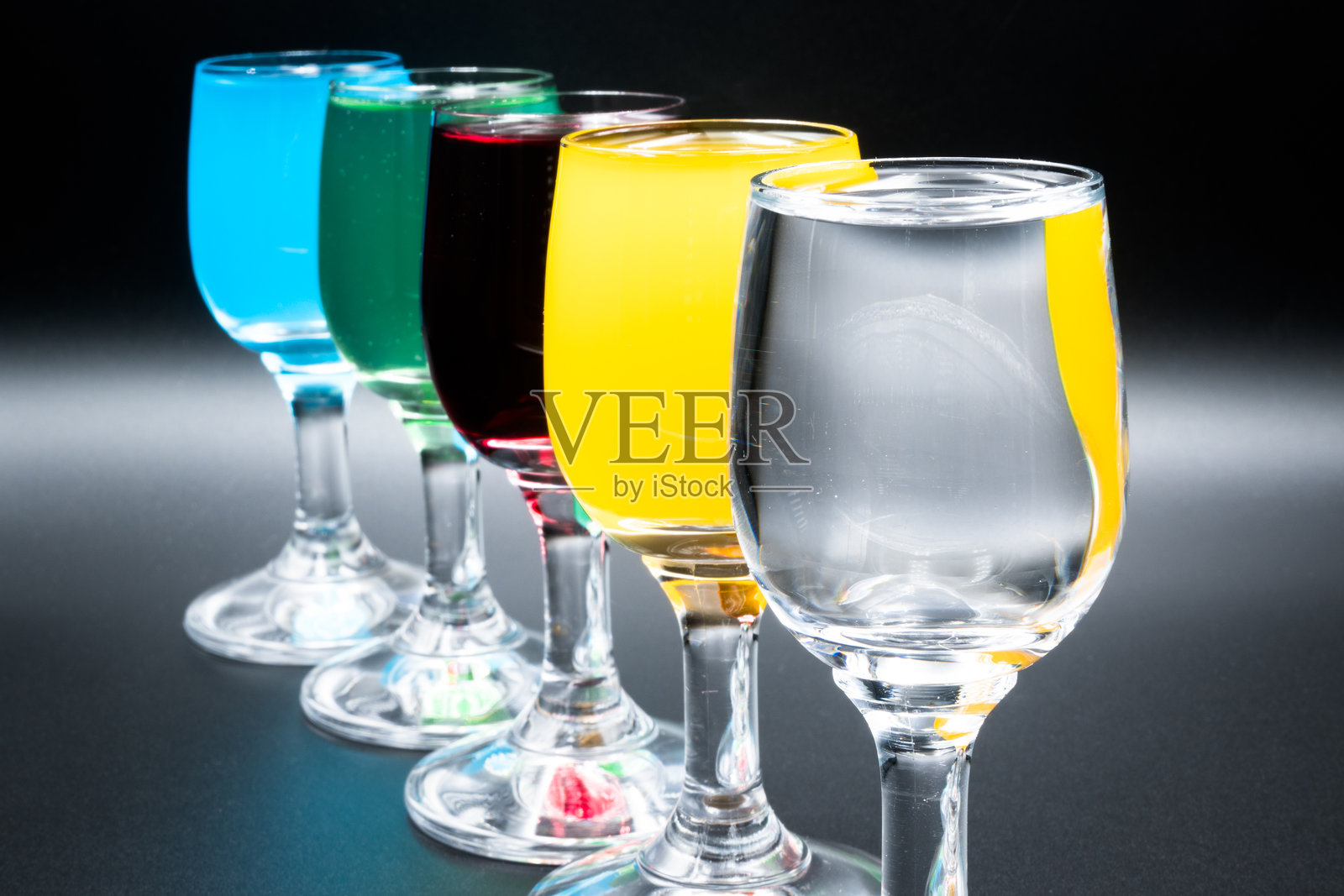 五颜六色的酒在酒杯中。照片摄影图片