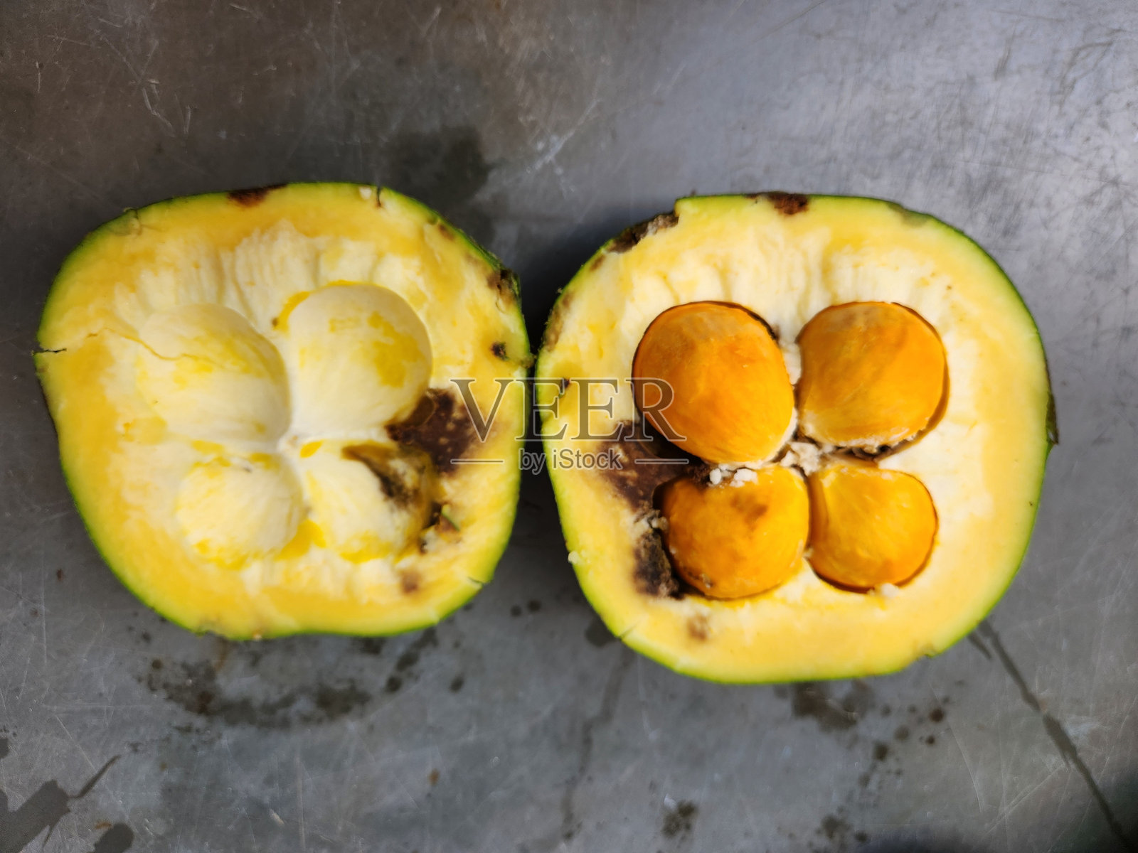 巴西榈果（Caryocar brasiliense）：巴西热带草原（塞拉多）的标志性水果，从刺皮到黄色果肉，浓烈的风味和异国情调的口感，切开的巴西榈果，果肉与种子的分界，切片的巴西榈果（内部观察）照片摄影图片