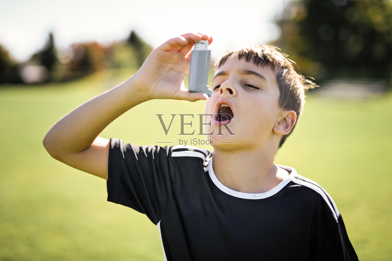 年轻的足球运动员手中拿着吸入器照片摄影图片
