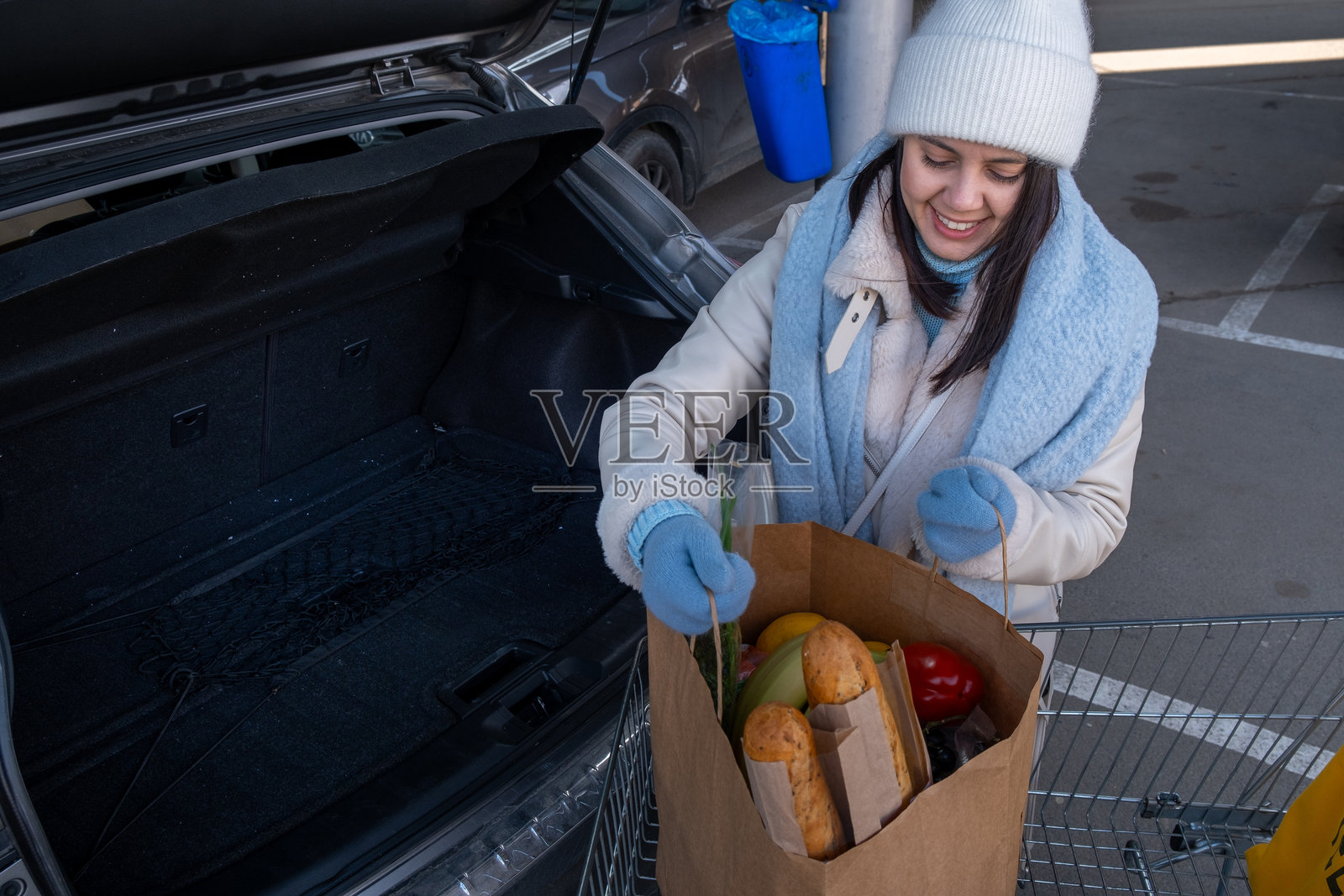 女人将杂货放入汽车中照片摄影图片