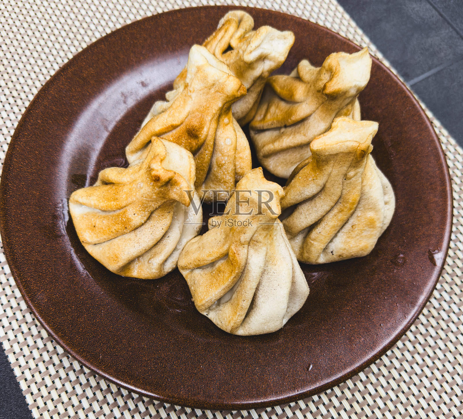 盘子里的炸饺子放在桌子上照片摄影图片