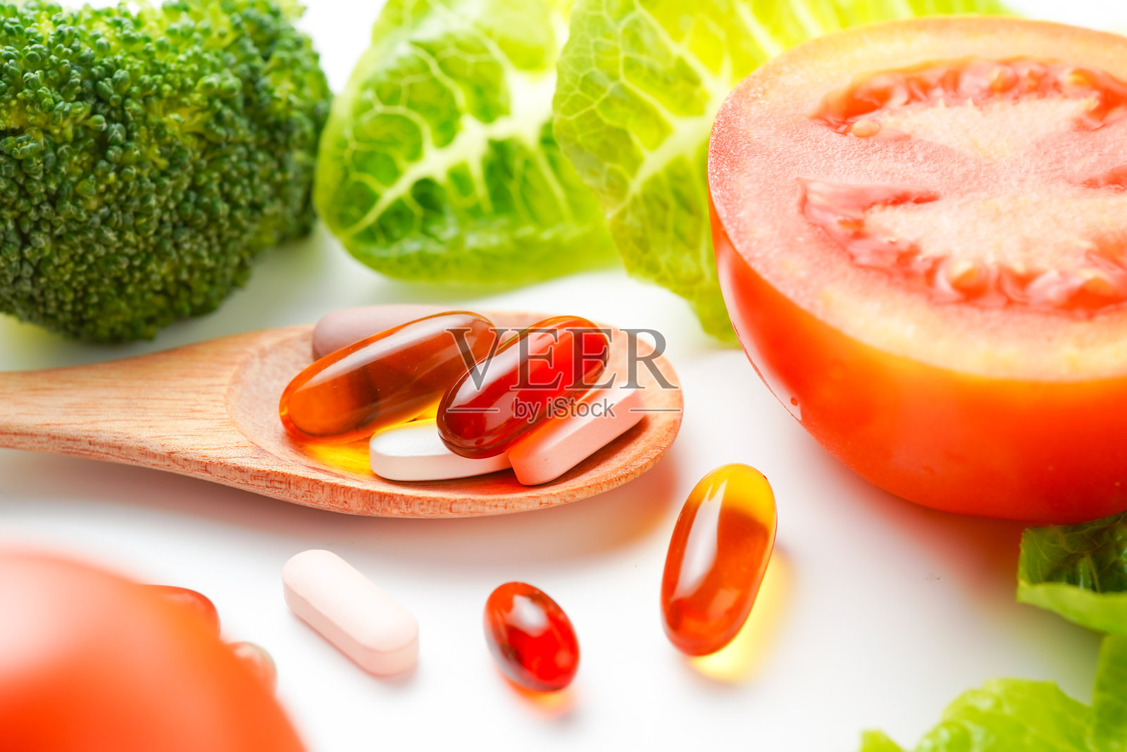 木勺中的药丸和胶囊与新鲜蔬菜，复合维生素和补充剂照片摄影图片