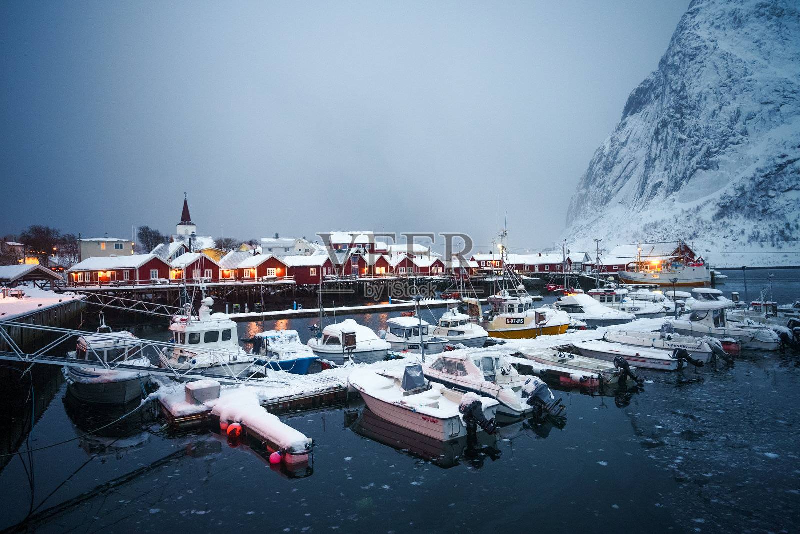探索挪威的冬季港口，欣赏雪-covered的船只和迷人舒适的小屋照片摄影图片