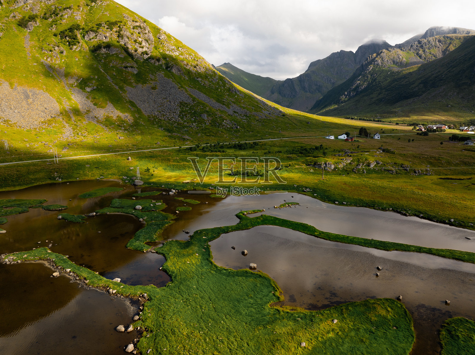 壮观的鸟瞰图，展现了被雄伟山脉环绕的美丽郁郁葱葱的山谷照片摄影图片