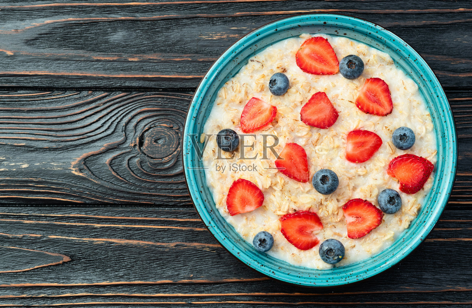 自制早餐。牛奶燕麦粥配浆果。俯视图照片摄影图片