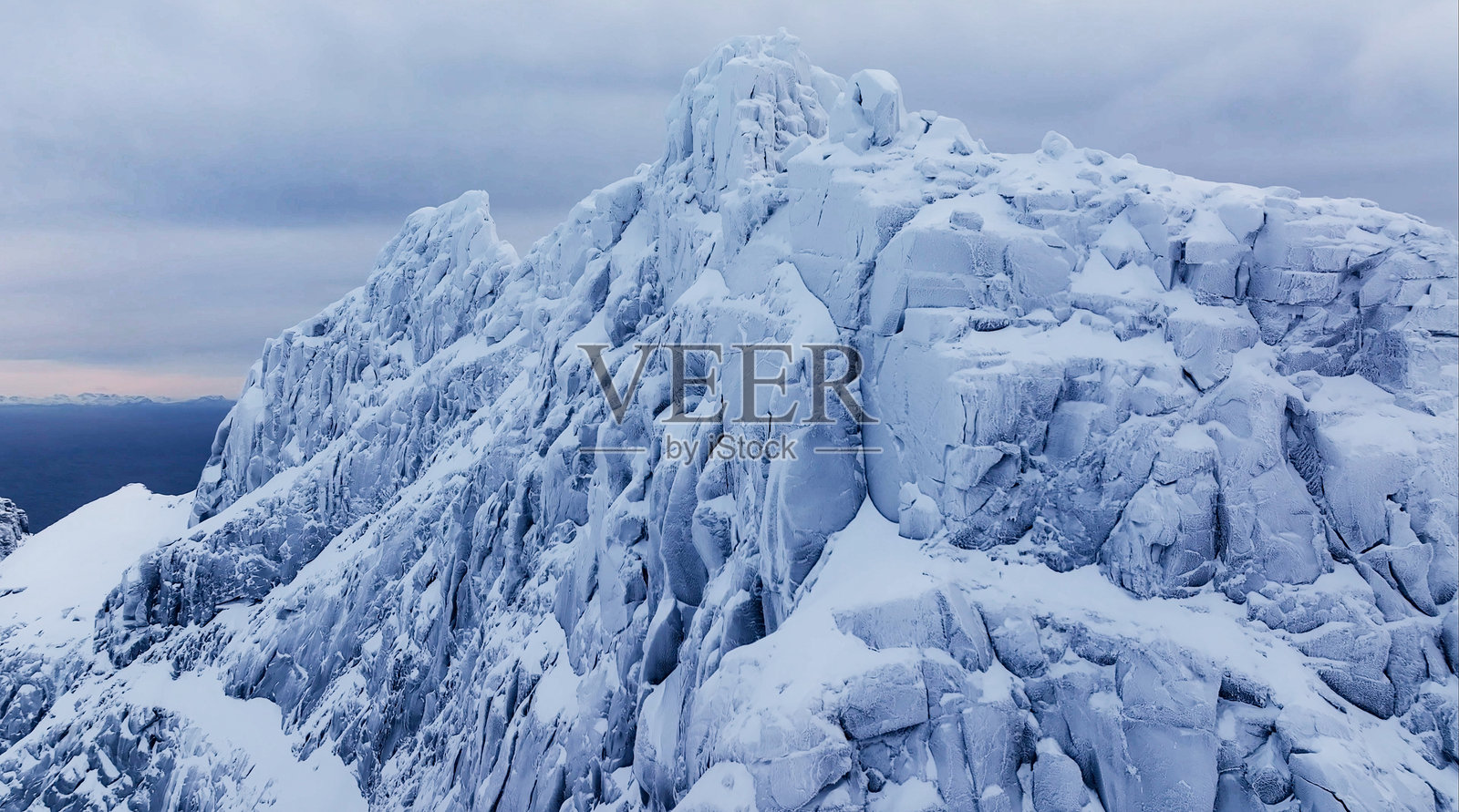 雄伟壮丽的冰雪覆盖山峰在阴云密布的天空下耸立照片摄影图片