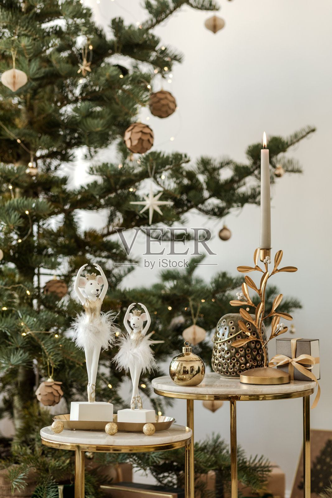 温馨客厅里的圣诞树，装饰着白色和金色的饰品。优雅而节日气氛浓厚的家居装饰。照片摄影图片