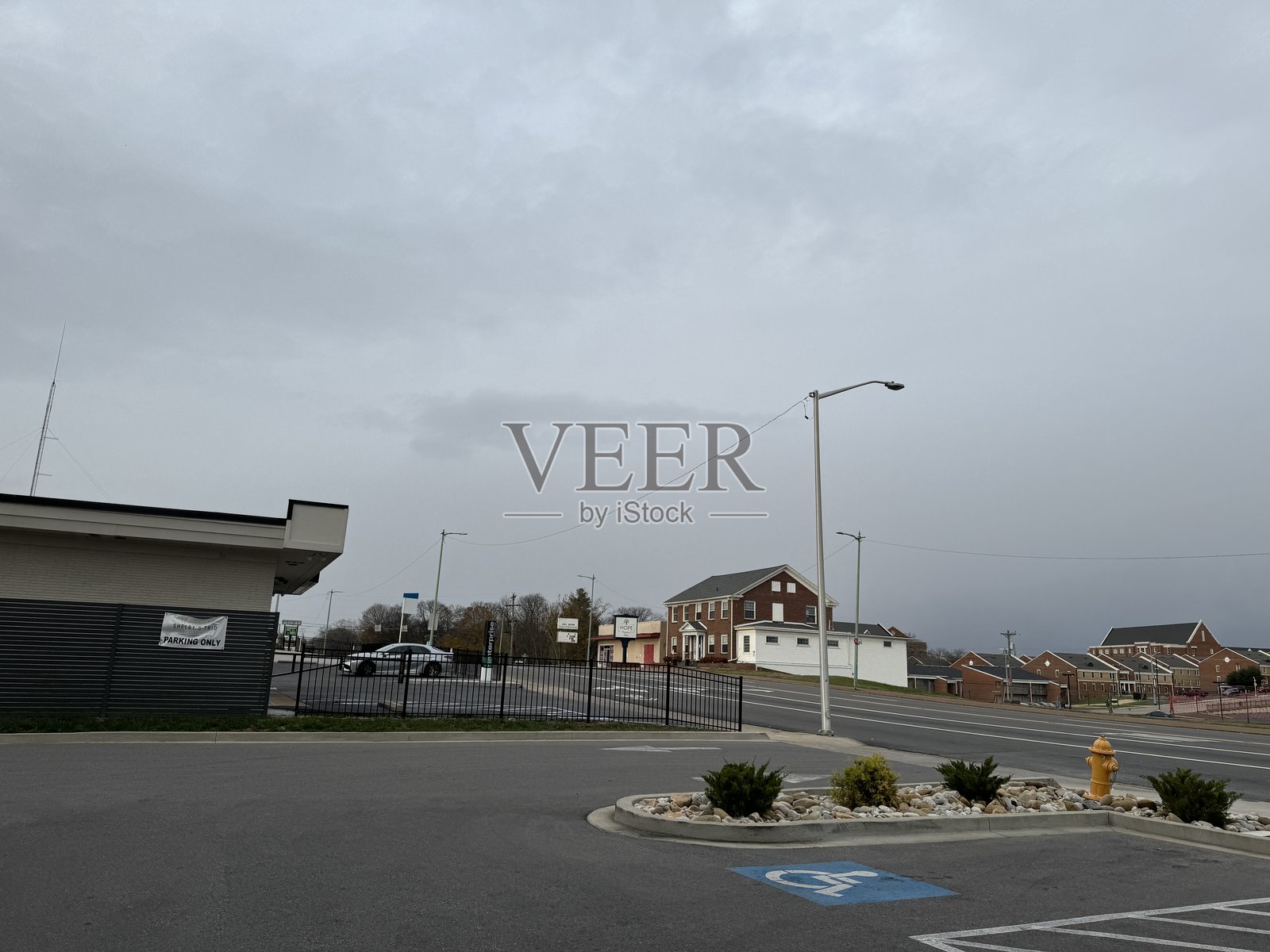 阴云密布的天空覆盖着城市交叉口，周围是建筑和购物区附近的交通。照片摄影图片