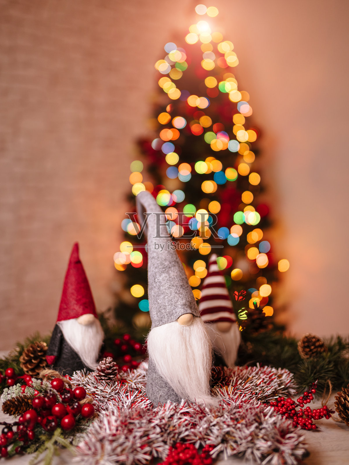 节日圣诞侏儒装饰，背景中有装饰品和虚化的圣诞树照片摄影图片