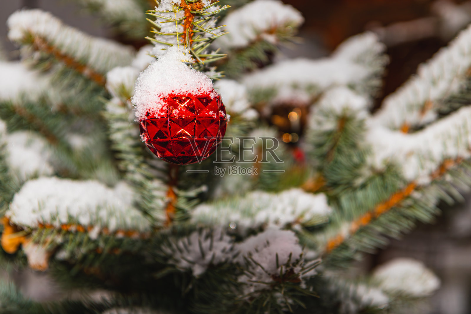 一棵装饰着节日装饰品并洒上柔软雪花的圣诞树照片摄影图片
