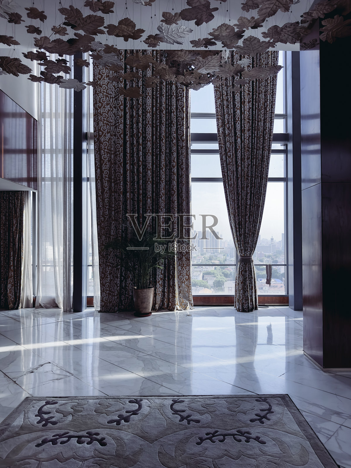 一间宽敞现代的高层建筑活动或会议室。这个空间设有大型落地窗，配有流畅优雅的窗帘，让自然光线充盈整个房间。照片摄影图片