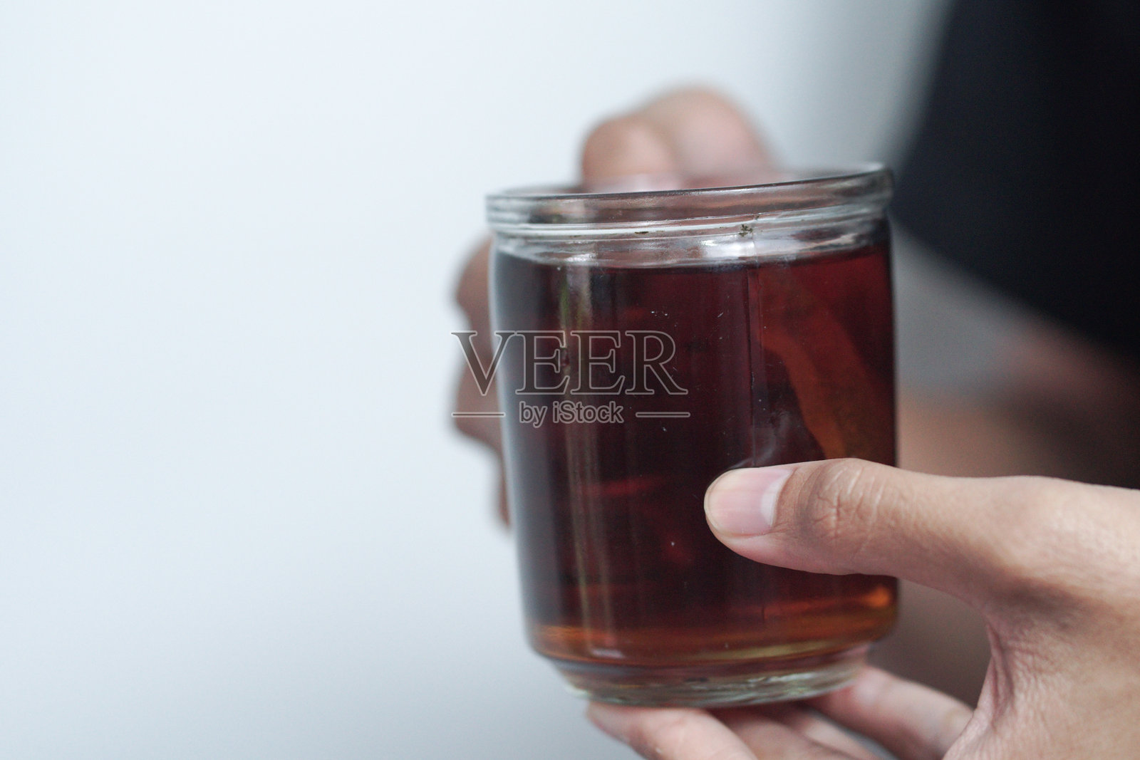 特写。男性手握着一杯热茶。照片摄影图片