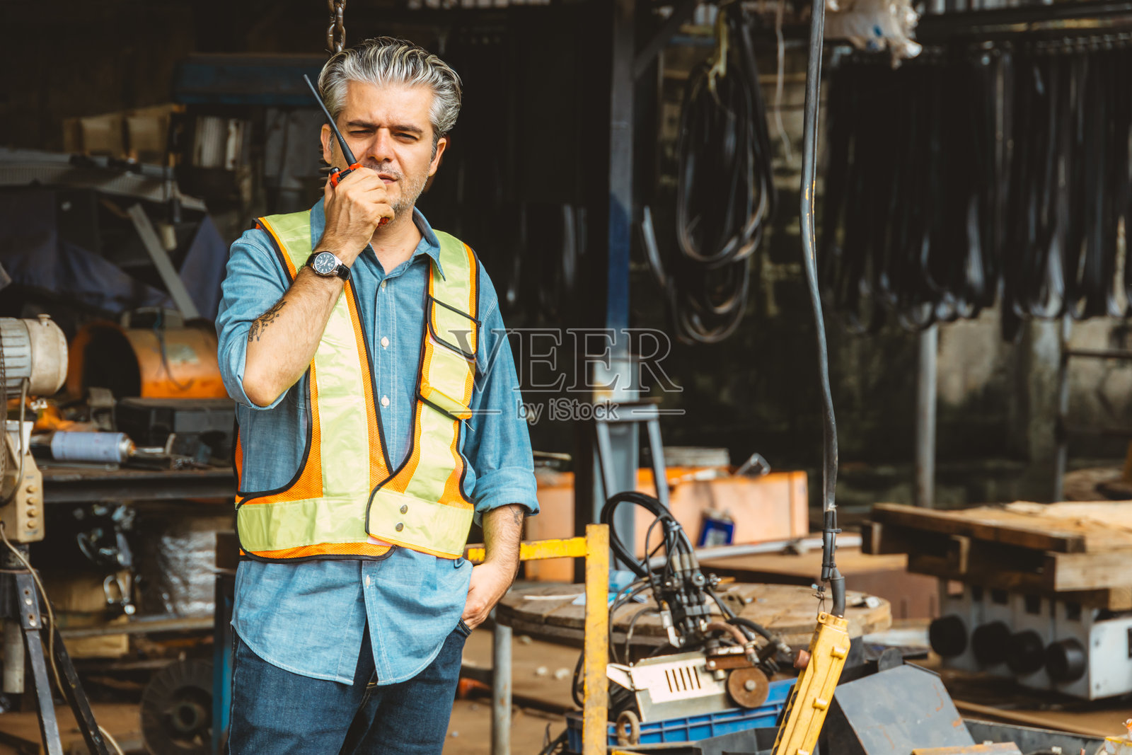 意大利工人在建筑工地控制无线电操作。工头通过对讲机指挥起重机工作。照片摄影图片