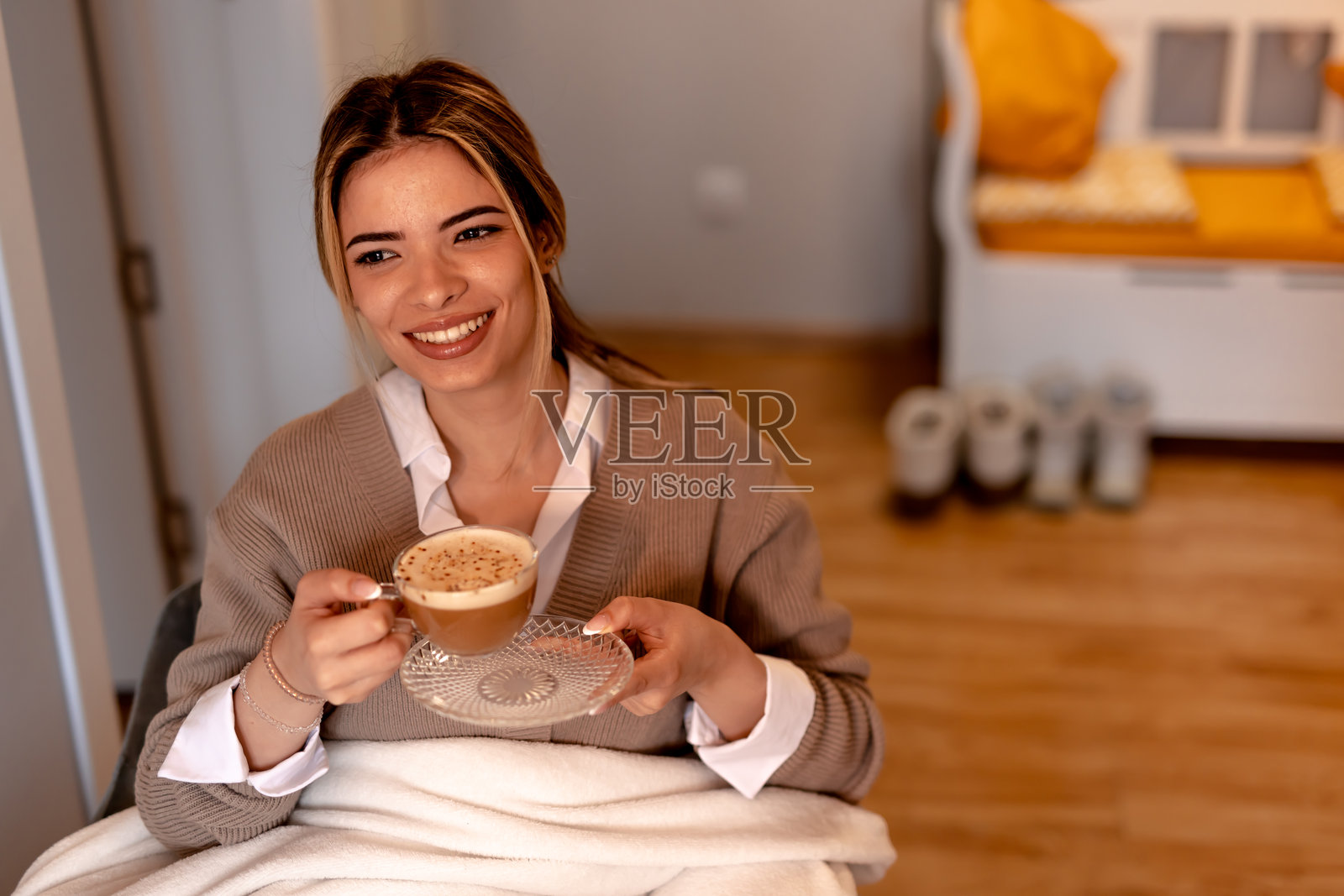 微笑的年轻女性在家中享受卡布奇诺照片摄影图片