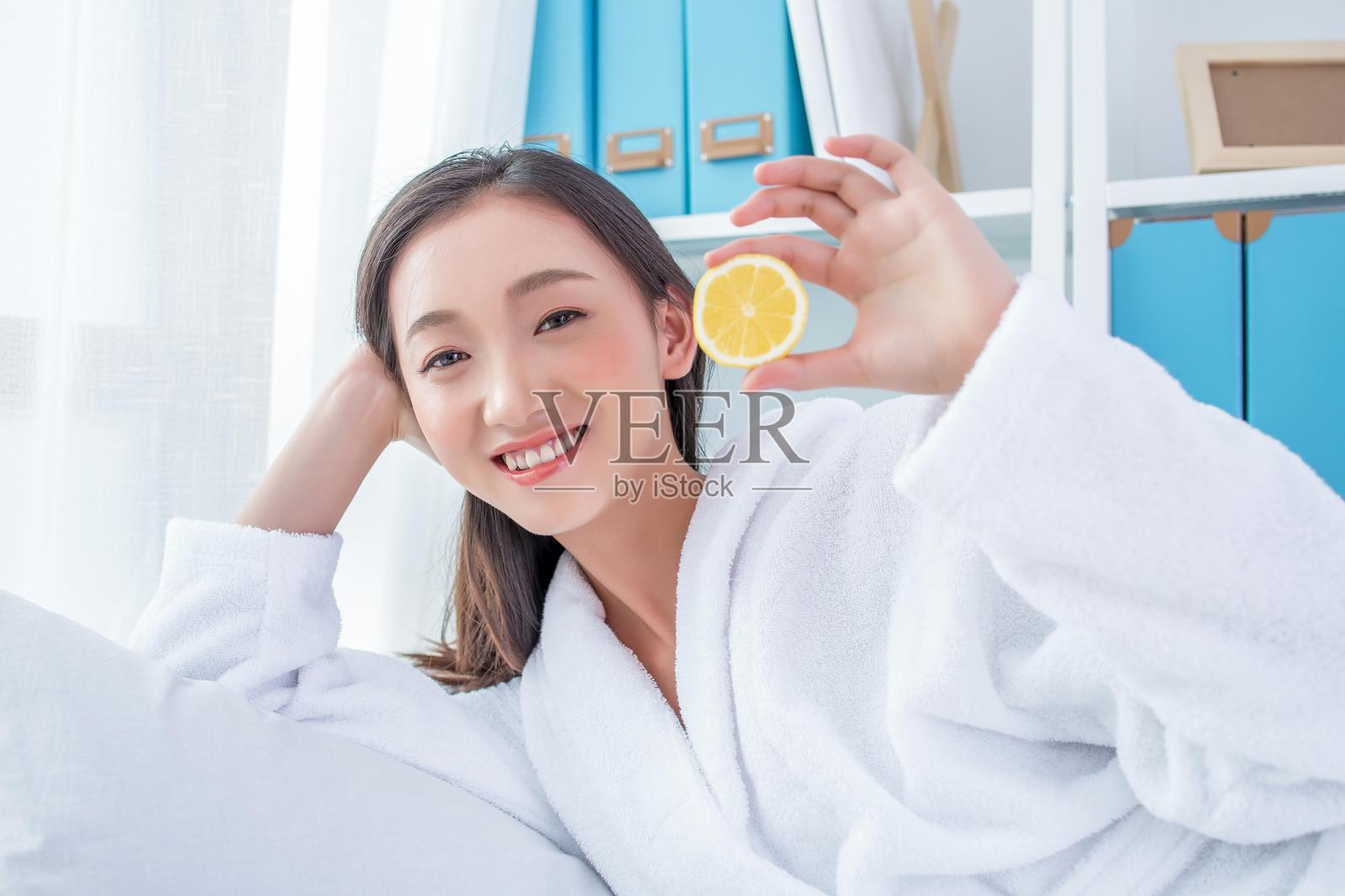 年轻的亚洲女性手持一个柠檬照片摄影图片