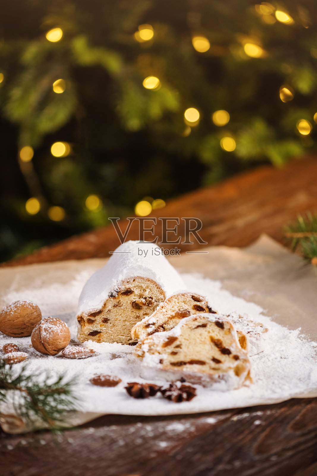木质背景上的圣诞斯托伦切片。传统的圣诞节节日糕点。斯托伦是圣诞节的美味佳品。照片摄影图片