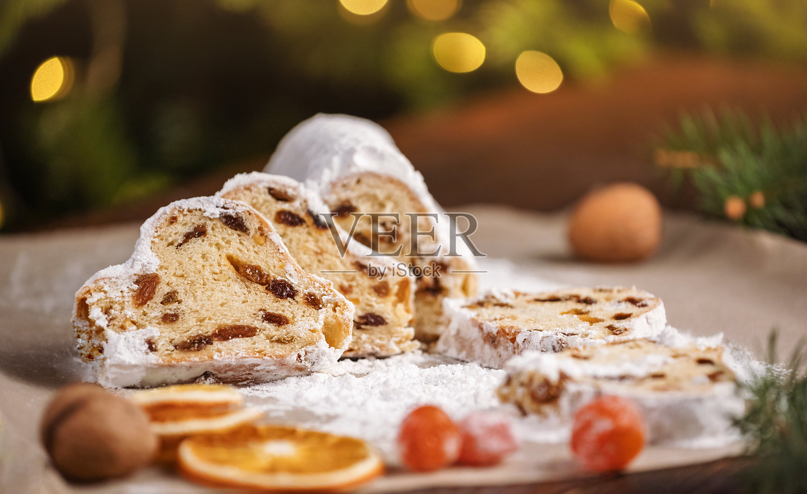 木质背景上的圣诞斯托伦切片。传统的圣诞节节日糕点。斯托伦是圣诞节的美味佳品。照片摄影图片