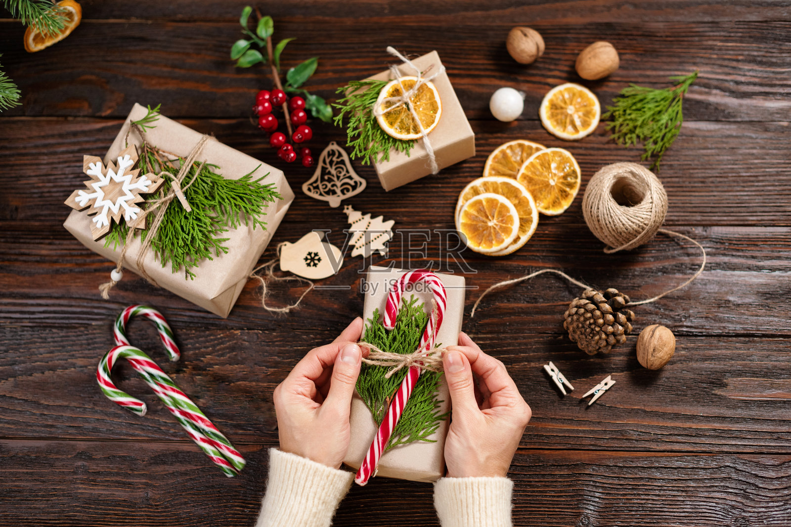 可持续的圣诞节。女性的手正在用手工纸包装圣诞礼物。环保圣诞假日概念。零浪费，环保。照片摄影图片