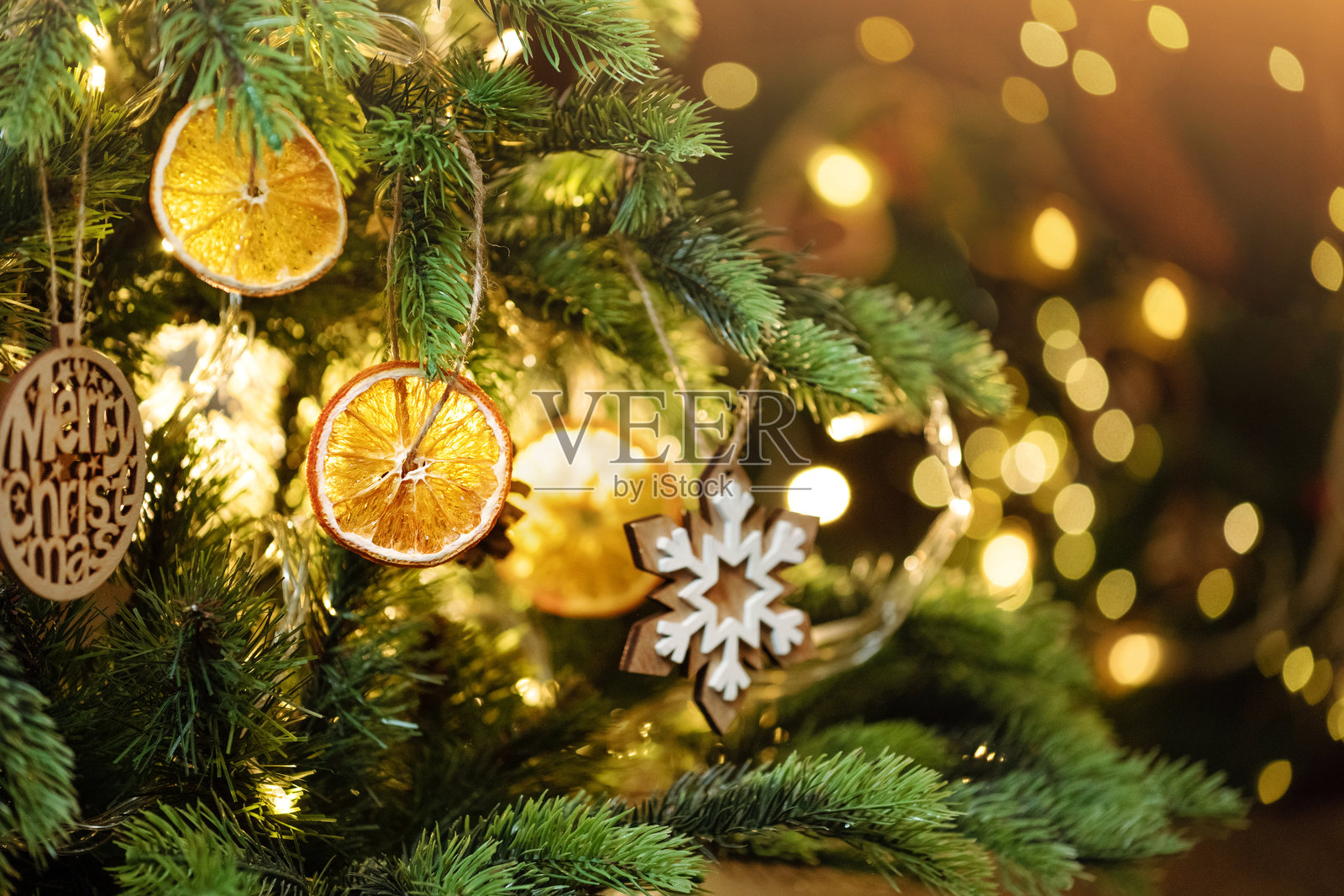 圣诞装饰。干橙片饰品和木质饰品挂在圣诞树上。环保圣诞节概念。零浪费，环保。可持续的圣诞节。照片摄影图片