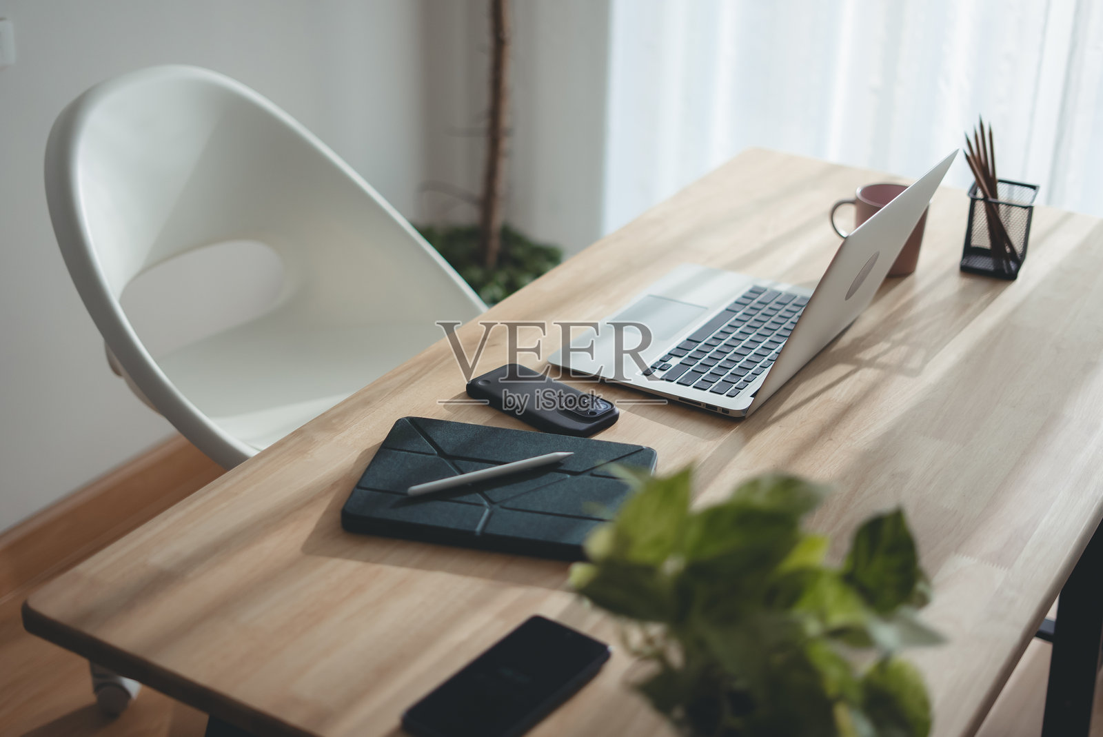 现代室内的木质桌子，上面放着笔记本电脑和办公用品。照片摄影图片