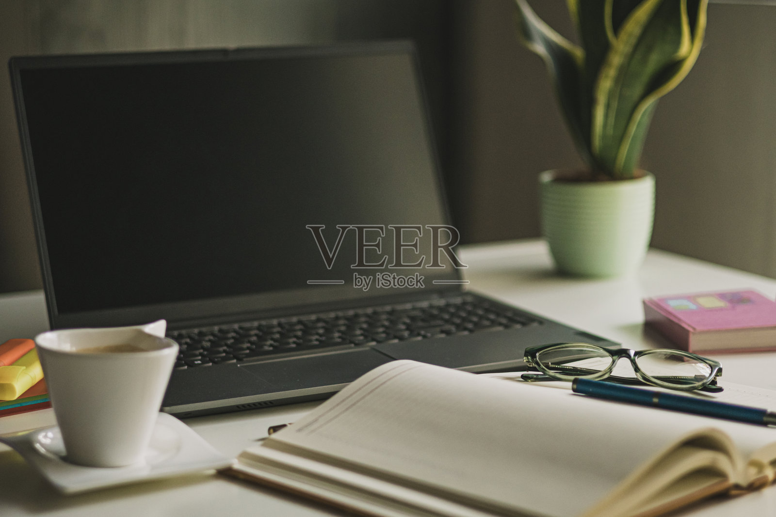女性办公室桌子。笔记本电脑、咖啡杯、阅读眼镜和办公用品。照片摄影图片